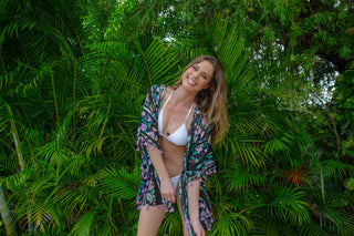 Model wearing a Sara Joy swimsuit Cover Up while standing in front of tropical plants.