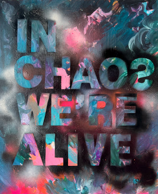 Abstract artwork by Sara Joy with the text "IN CHAOS WE'RE ALIVE" in bold letters. The background features colorful swirls of pink, blue, green, and black, creating a dynamic and vibrant effect.