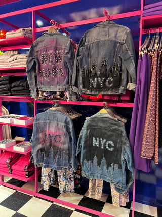 Sara Joy's hand painted NYC jean jackets hanging in Terez.