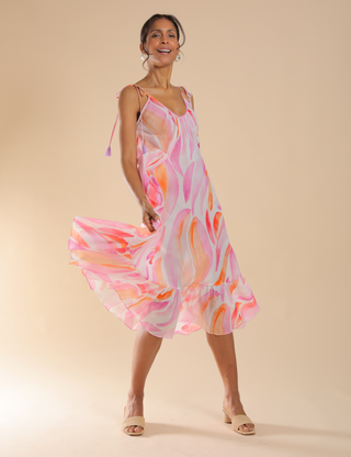 Model standing in front of tan background wearing a Sara Joy Dress.